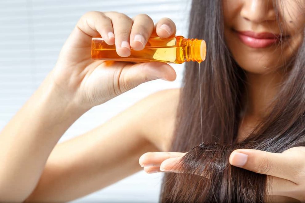 Chica cuidando el cabello con aceite capilar
