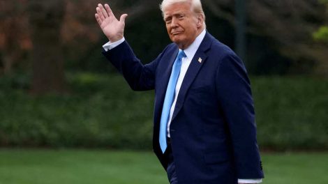 Donald Trump saluda desde un jardin