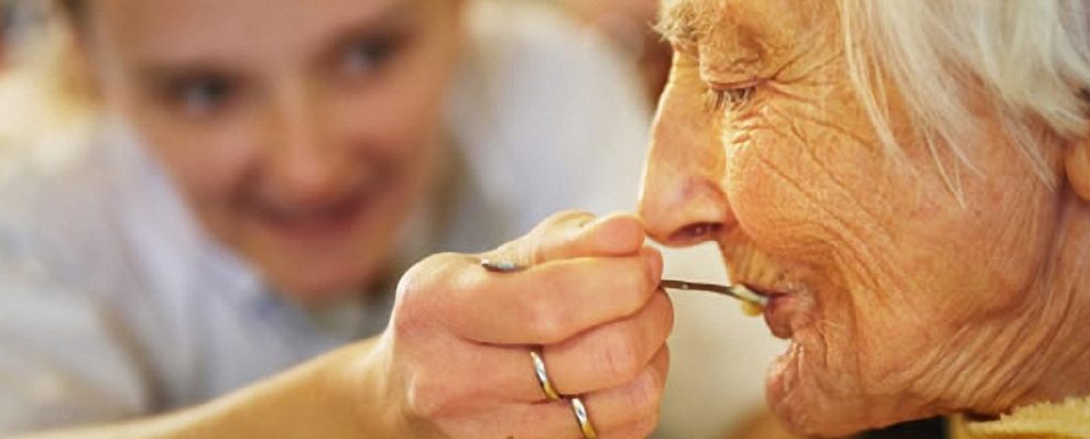 mujer alimentando a una anciana