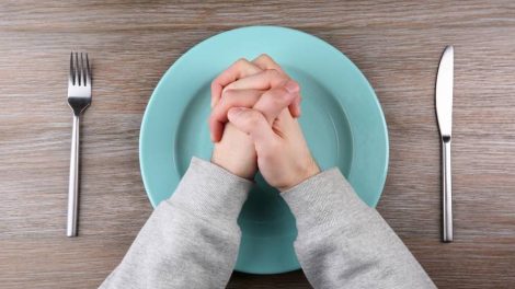 manos cruzadas encima de un plato