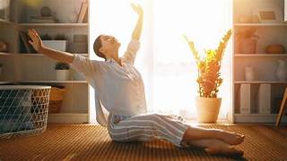 mujer en el suelo de su hogar estirando los brazos