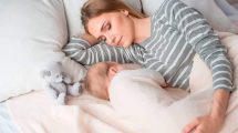 Mujer durmiendo con su bebé