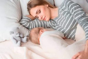 Mujer durmiendo con su bebé