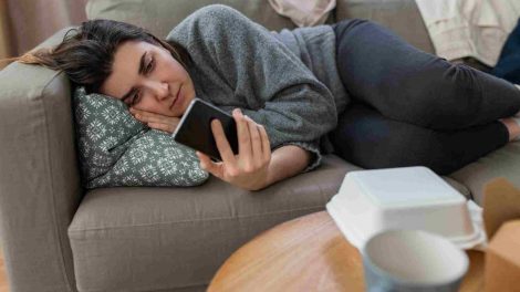 persona acostada viendo el celular