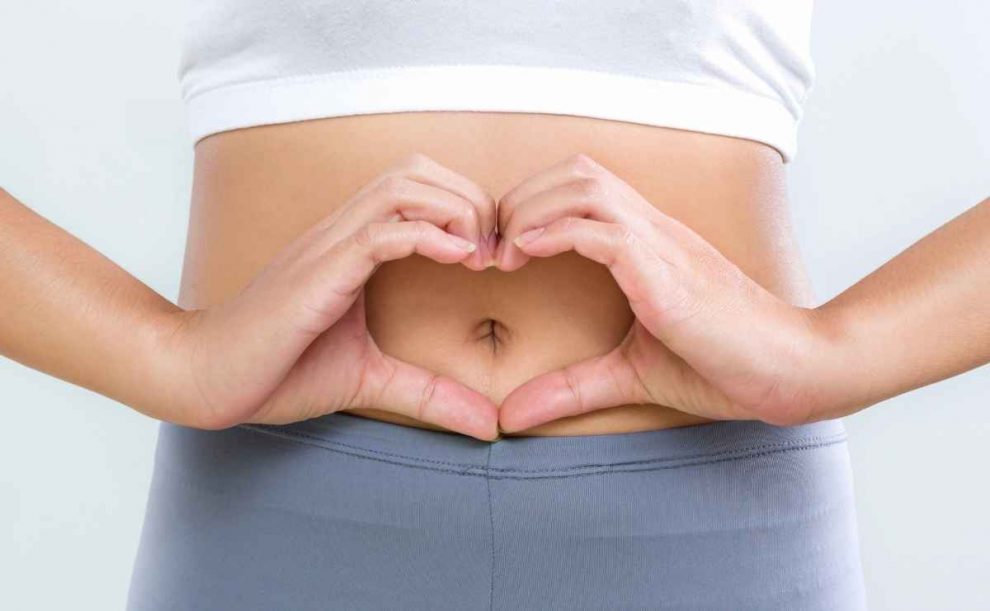 Manos formando un corazón en el abdomen
